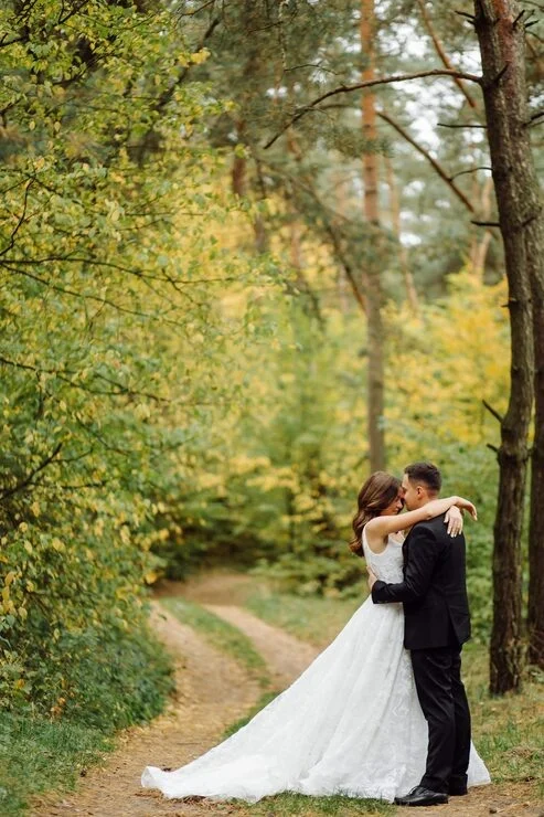 Ein Hochzeitspaar auf einem Waldweg